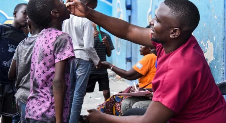 Een man die het cholera -vaccin toedient aan een kind in een tijdelijk cholera -behandelingscentrum dat werd opgericht om de laatste epidemie van dodelijke cholera onder ogen te zien, in het Lusaka National Stadium Heroes, Zambia, 17 januari 2024 Reuters / Namukolo Siyumbwa