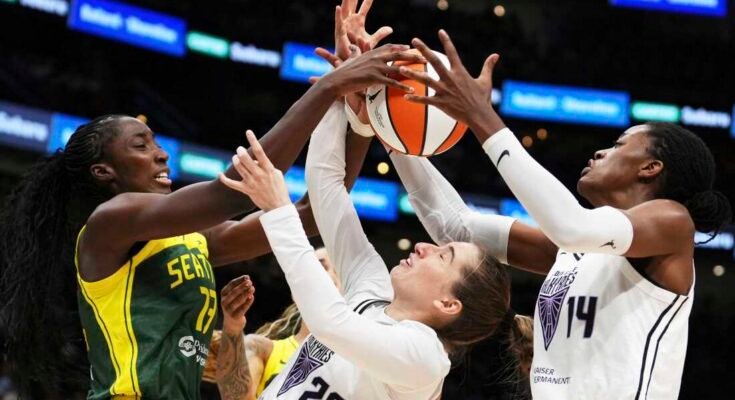De Golden State Valkyries Kate Martin (20) doelman heeft problemen met het handhaven van bezit tegen de Seattle Storm -spits Ezi Magbegor (links), terwijl het centrum van Valkyries Temi Fagbenle (14) de bal bereikte in de tweede helft van een WNBA -wedstrijd in Seattle. De Valkyries debuteerden dit seizoen als 13th League -team.