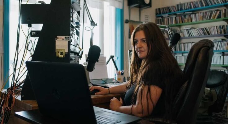 Abby Dufour, WCHG News -journalist en Dufour's middag van de dag, geeft het volgende nummer van zijn uitzending op WCHG 107.1 FM Station, in Hot Springs, Virginie, vrijdag 18 juli 2025. Credit: Kristian Thacker voor NPR voor NPR